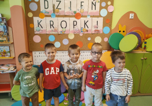 Chłopcy pozują do zdjęcia na tle dekoracji "Dzień Kropki"
