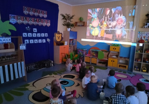 zdjęcie dzieci na dywanie patrzących na ekran