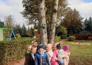 Dzieci przytulają się do drzewa