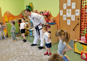 Dzieci wykonują wspólną rozgrzewkę z Panem z Taekwondo