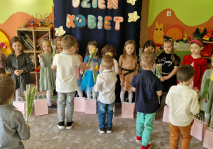 Chłopcy wręczają swoim koleżankom żółte tulipany