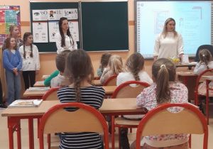 Dzieci siedzą w ławkach