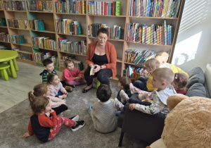 Pani bibliotekarka opowiada dzieciom o zasadach wypożyczania książek