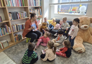 Pani bibliotekarka zachęca dzieci do założenia karty w bibliotece