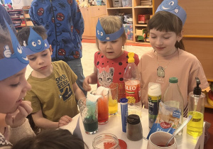 Dzieci obserwują doświadczenia z wodą.