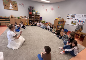 Pani tłumaczy dzieciom sposób wykonania zajączka.