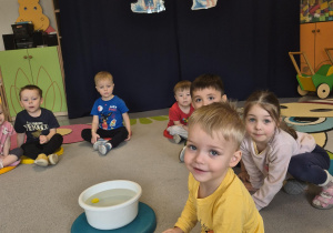 chłopiec sprawdza czy wybrany przedmiot pływa czy tonie