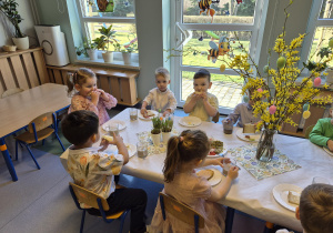 dzieci jedzą śniadanie wielkanocne