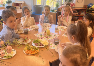 Dzieci siedzą przy stole .