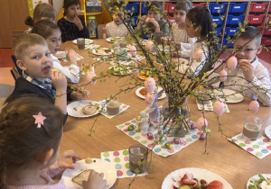 Przedszkolaki nakładają sobie jedzenie na kanapki.