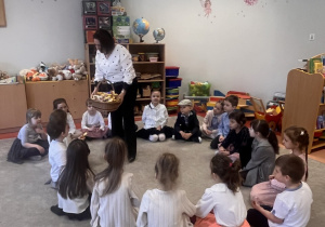 Pani dyrektor rozdaje czekoladowe zajączki.