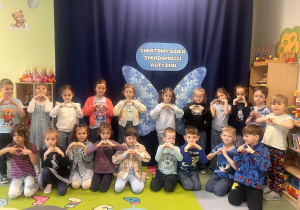 Przedszkolaki robią zdjęcie na tle dekoracji.