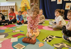 Dziewczynka symbolicznie sadzi marchewki.