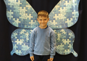 chłopiec na tle niebieskich skrzydeł