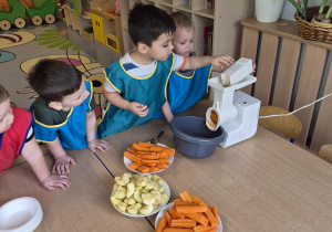 dzieci ścierają marchewkę i jabłka