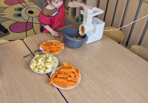 chłopiec pomaga przy robieniu surówki