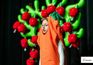 Zuzia recytuje wiersz na scenie .