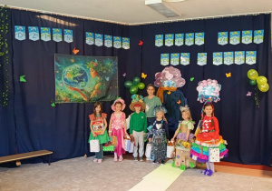 Dzieci pozują do zdjęcia na tle dekoracji.