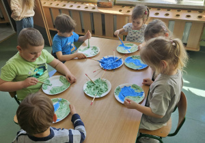 Przedszkolaki malują kule ziemską.
