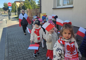 Dzieci w trakcie pochodu z flagami.