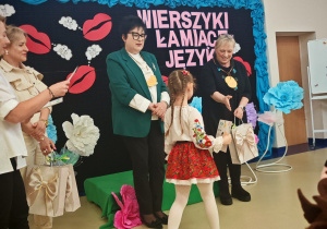 Dziewczynka odbiera dyplom i nagrodę