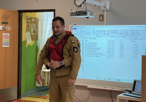 Strażak pokazuje co należy zrobić w razie zakrztuszenia.