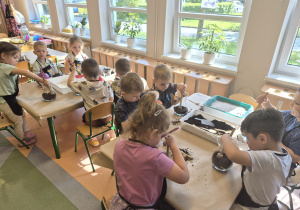 przedszkolaki układają kolejne warstwy w słoikach