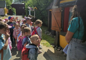 Przedszkolaki stoją przed domkiem z kolejną bajką,