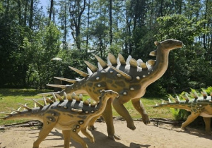 Zdjęcie przedstawia posąg dwóch dinozaurów.