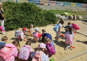 Chłopcy i dziewczynki szukają szkieletów dinozaurów.