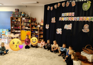 dzieci siedzą na dywanie