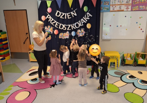 dzieci próbujące złapać bańki