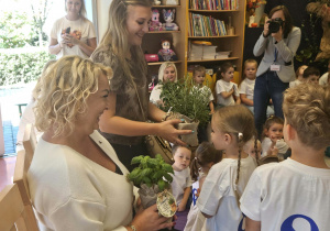 Przedszkolaki wręczają gościom prezenty.