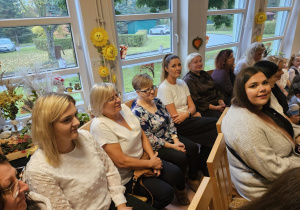 Pracownicy przedszkola siedzą na krzesłach.