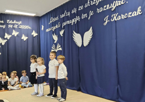Chłopcy i dziewczynki stoją na tle dekoracji.