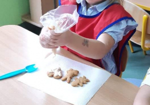 Dziecko zdobi ciasteczka.