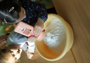 Dzieci robią masę plastyczną z mąki i balsamu do mycia.