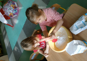 Dzieci robią masę plastyczną z mąki i balsamu do mycia.