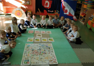 Dzieci prezenują wspólnie wykonany obrazek.