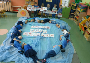 Dzieci ułożone na dywanie w formie serca.