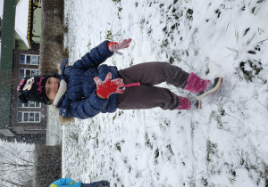 Dziewczynka biega po sniegu.