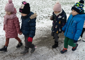 Dzieci idą na zimowy spacer.