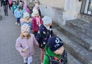 Dzieci idą ulicami Grocholic z kukłą Marzanny.