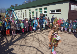 Dzieci na placu zabaw uczestniczą w obrzędzie pożegnania zimy - palenia marzanny