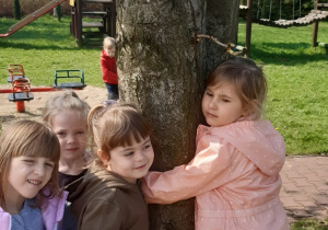 Dzieci obejmują duże drzewo kasztanowca.