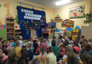Dzieci słuchają bajek czytanych przez wychowawcę grupy "Elfy"