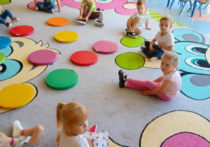 dzieci siedzą na kolorowych krążkach