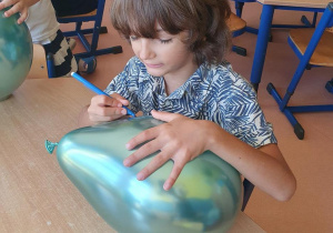 Chłopiec maluje balon