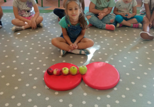 dziewczynka układa jabłka