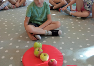 chłopiec układa jabłka